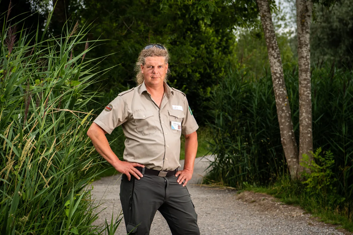 Für Greifensee-Ranger Niklas Göth ist das Füttern der Vögel grundsätzlich nicht nötig. Er rät deshalb zur Zurückhaltung. (Archiv) Ein Mann steht mit in die Hüften gestemmten Armen auf einem Weg.